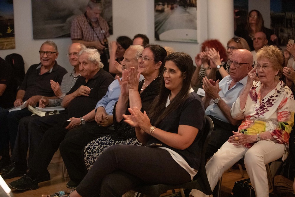 קהל יושב ומאזין להקראה ולמוזיקה
